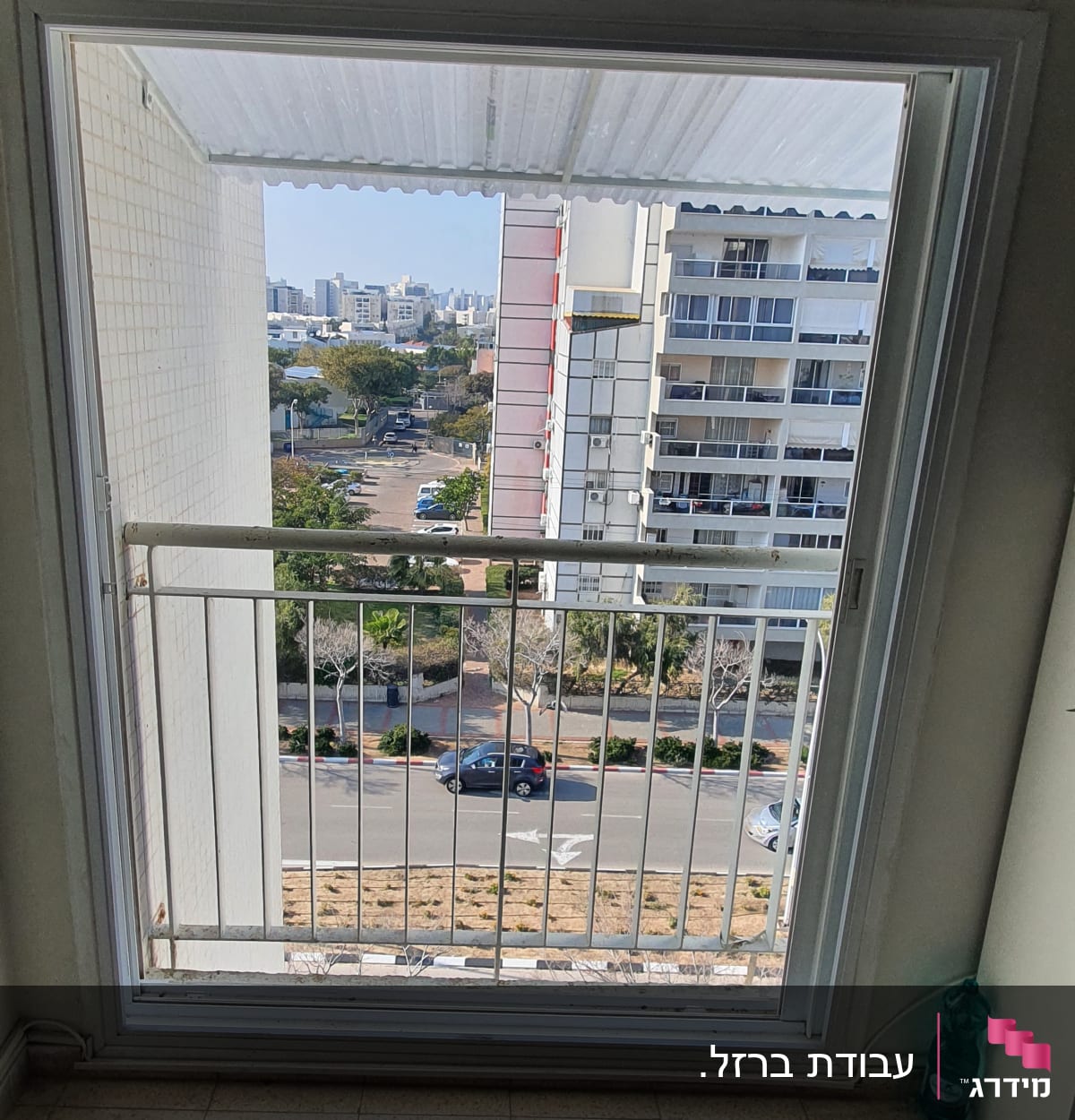 חלון עם מסגרת מתכת ונוף עירוני